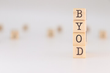 BYOD acronym. Concept of Bring Your Own Device written on wooden cubes isolated on white background.