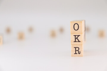 OKR acronym, Concept of Objectives, Key and Results written on wooden cubes isolated on white backgorund
