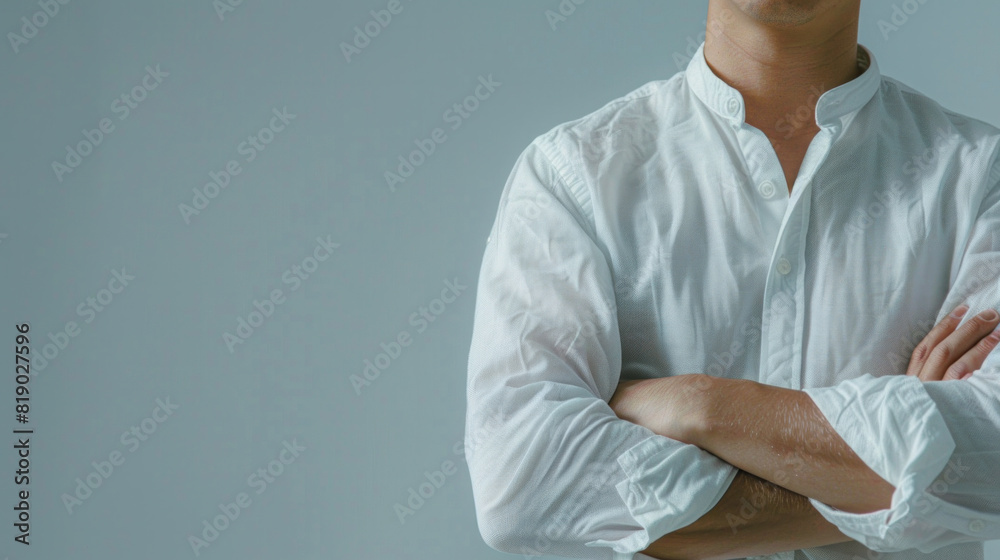 Wall mural A man is wearing a white shirt and has his arms crossed. The shirt is wrinkled and he is wet