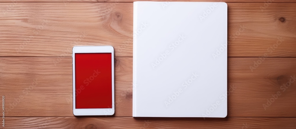 Aufkleber Red notebook and white tablet on a table with a wooden texture. copy space available
