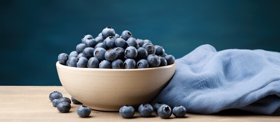 fresh blueberries in blue bowl on linen cloth wide photo. copy space available