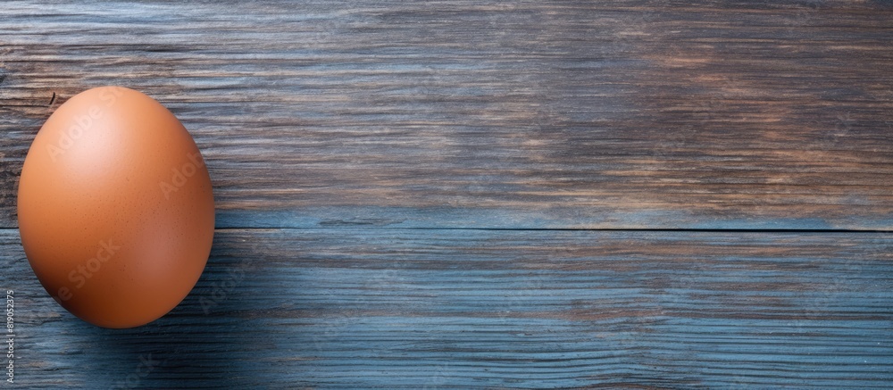 Aufkleber brown raw chicken egg in shell on old blue wooden background close up top view. copy space available