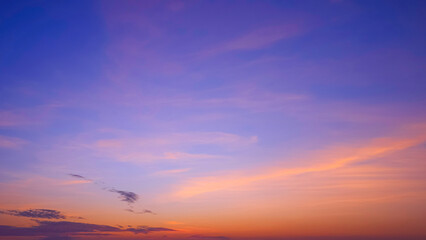 Sunset sky background with colorful orange and pink clouds on idyllic blue evening twilight sky, beautiful romantic sunrise sky backdrop