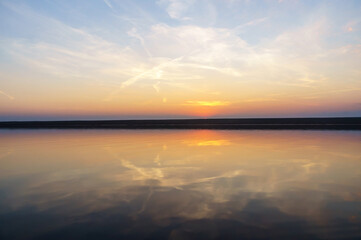 Obraz premium Reflection of the sunset in the water. Beautiful sunset over the sea. Colored sky at sunset.