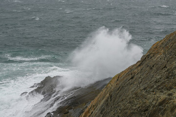 Fototapeta premium Large Wave Crashes Into Rocks Near Ocean