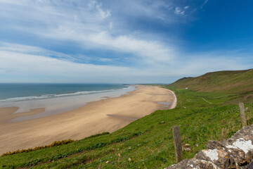 Rhossili bay with small surfing waves