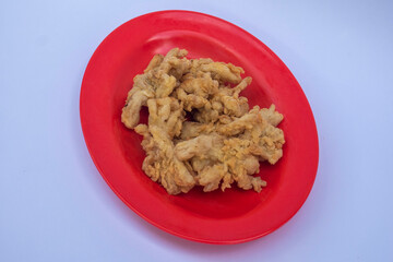 Crispy mushrooms on a red plate with white isolated object.