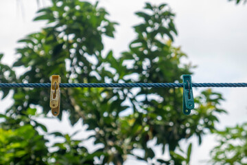 Yellow and blue clothespins. Indonesian style of drying clothes.