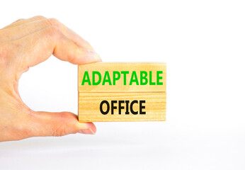 Adaptable office symbol. Concept words Adaptable office on beautiful wooden block. Beautiful white paper background. Businessman hand. Business Adaptable office concept. Copy space.