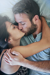Passion, man and woman in bed with kiss, romance and morning bonding in apartment. Relationship,...
