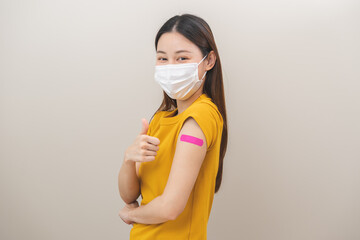 Healthcare of Covid-19, corona anti virus vaccination, happy asian young woman hand showing like at bandage, plaster on arm, getting vaccine immunity giving injection influenza to protection pandemic.