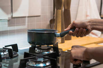 Man Lighting Electric Stove in Modern Kitchen