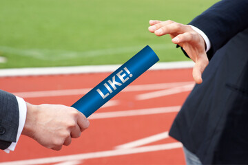 Businessman passes LIKE baton in stadium relay race social media concept