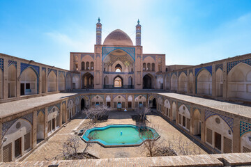 The peaceful courtyard of the Agha Bozog Mosque features a reflecting pool and showcases Persian...