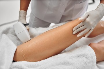 Laser epilation of legs in a beauty salon.