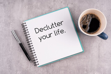 Notepad with text declutter your life and cup of coffee