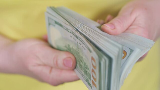 Female Hands Counting Us Dollars. Dollar Bills In Hands. Short Manicure Counting Money. Girl Is Holding A Wad Of Dollars In Her Hands. Close up.