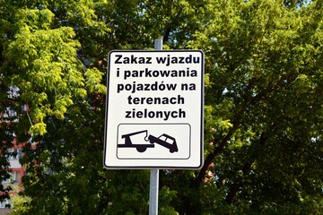 Road sign towing a car with a board with Polish words prohibiting the entry and parking of vehicles...