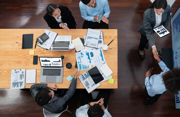 Top view diverse coworker celebrate with handshake and teamwork in corporate workplace. Happy...