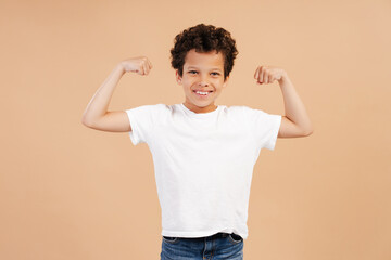 Smiling handsome African American boy wearing white t shirt, mockup, showing biceps on hands