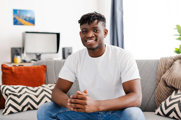 Happy handsome African American young man wearing stylish casual white t shirt, looking at camera