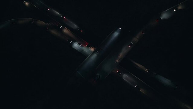 Top View shows a nighttime overpass with car traffic traveling in complete darkness with their headlights illuminating path at an interchange in Dartmouth, Canada. Development of transport 