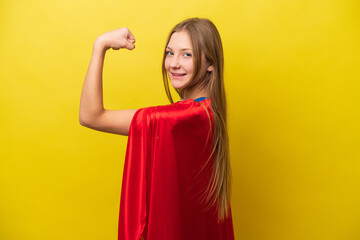 Young Russian woman isolated on yellow background in superhero costume and doing strong gesture
