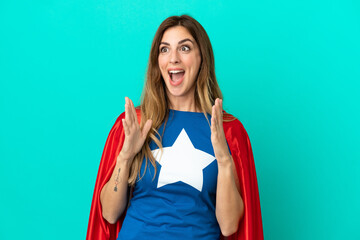 Super Hero caucasian woman isolated on blue background with surprise facial expression