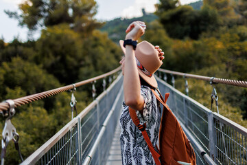 autumn mood. A female tourist walks along the bridge over the river. A young woman walks along a...