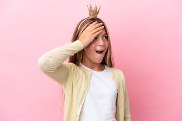 Little princess with crown isolated on pink background doing surprise gesture while looking to the side © luismolinero