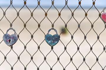 Love lock on wire from fence on beach