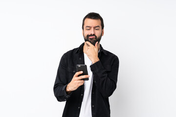 Fototapeta premium Young man with beard over isolated white background thinking and sending a message