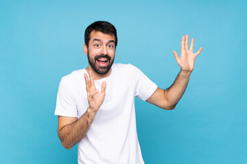 Fototapeta premium Young man with beard over isolated blue background nervous and scared