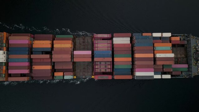 Top view container ship slowly sailing in Halifax Harbour as it enters the port to unload containers. Cargo ship carrying a container and sailing very fast for export cargo from a container yard port