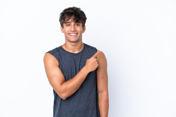 Young sport caucasian man isolated on white background pointing to the side to present a product