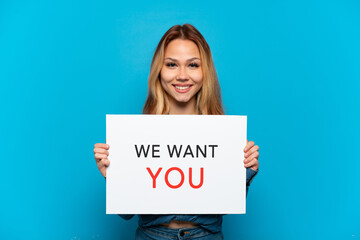 Teenager girl over isolated blue background holding We Want You board with happy expression