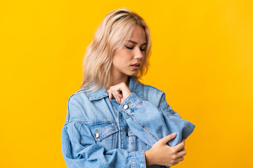 Young Russian woman isolated on yellow background with pain in elbow