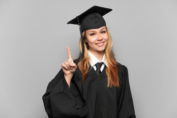 Young university graduate girl over isolated background showing and lifting a finger in sign of the best