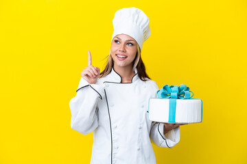 Young Russian pastry chef woman with a big cake isolated on yellow background thinking an idea...