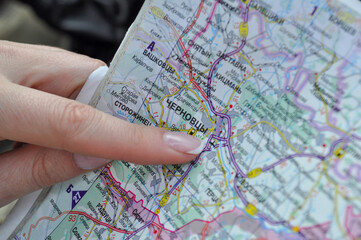 Map and hand pointing to the city of Chernivtsi, Ukraine