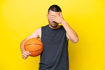 Young caucasian basketball player man isolated on yellow background covering eyes by hands. Do not...