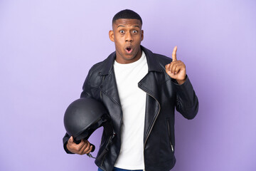 Latin man with a motorcycle helmet isolated on purple background intending to realizes the solution...