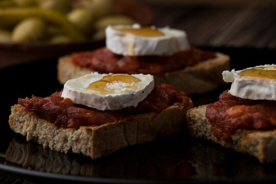 Three slices of toasted bread with sobrasada, goat's cheese and honey.