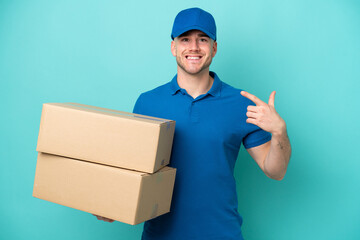 Delivery caucasian man isolated on blue background giving a thumbs up gesture