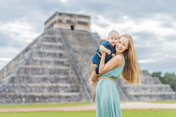Beautiful tourist woman and her son baby observing the old pyramid and temple of the castle of the...