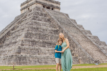 Beautiful tourist woman and her son observing the old pyramid and temple of the castle of the Mayan...