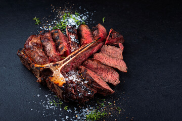 Barbecue dry aged chianina porterhouse beef steak with crystal salt and thyme served as close-up on...