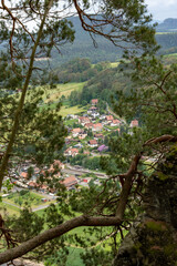 A view of a small town with houses and a church. The town is surrounded by trees and has a peaceful atmosphere