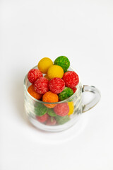 Round, bowl multi colored sugar candies. Sweet multicolor candies on glass cup. Top view.