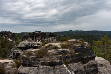 A rocky mountain top with a cloudy sky in the background. The sky is overcast and the mountain is covered in rocks